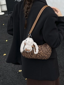 Vintage-Zylindertasche mit Leopardenmuster und weißem Plüschhasen-Anhänger am Modell
