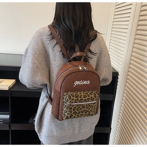 Detail der Tasche mit Leopardenmuster und Logo auf diesem braunen matten Lederrucksack