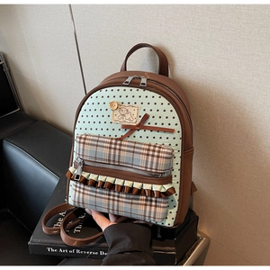 Mini bow backpack with sheep patch and plaid front pocket on vintage books