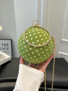 Green polka dot spherical chain handbag with crystal handle shown in hand