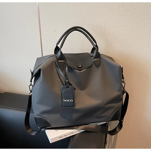 Dettaglio della borsa da viaggio in nylon con finiture in pelle NOCO e ampia tracolla
