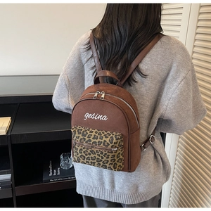 Detailansicht der Rückseite eines braunen Wildleder-Rucksacks mit Leopardenmuster-Tasche