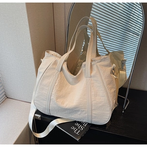 Detail van de crèmekleurige oversized shopper met versterkte handgreep en D-ring haken