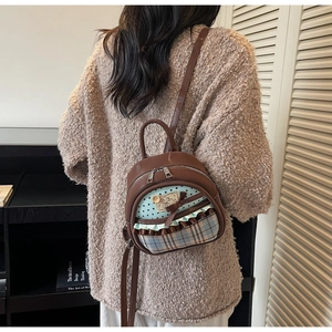 Detail of brown mini backpack featuring mint green star pattern and cute lamb patch