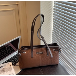 Close-up of brown tote bag with leopard print stitching and Sunny Day metal logo