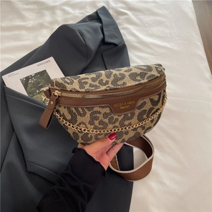 Detailed macro view of leopard print crossbody bag with gold chain and wide shoulder strap