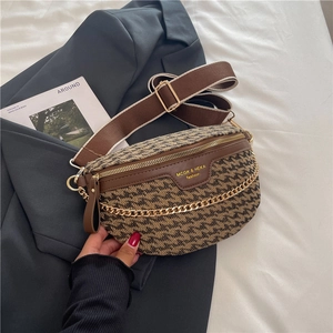 Detailed view of leopard print textured chest bag with wide strap and gold chain detail