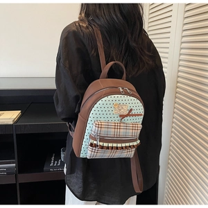 Detail of a brown school backpack featuring star patterns and decorative bow ruffles