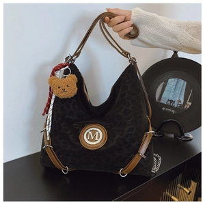 Detail of leopard print hobo bag with brown leather straps and metal M logo