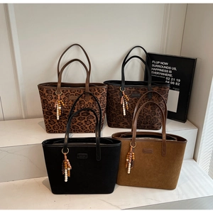 Collection of leopard print and solid faux suede tote bags with decorative wood bead tassels