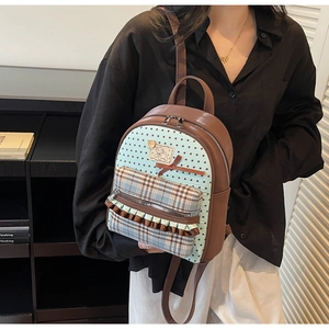 Detail view of the brown bow backpack showing adjustable straps and stylish pattern design