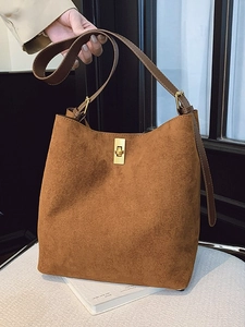 Brown suede bucket bag with gold lock and adjustable strap for shoulder or crossbody use