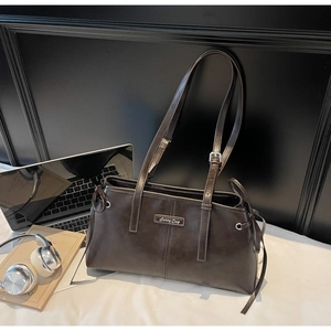 Detail of vintage brown shoulder bag with silver Sunny Day plate and leather texture