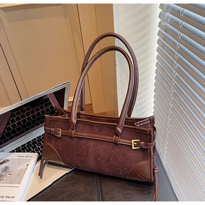 Detailed texture of dark brown suede and leather splicing with gold buckle accents