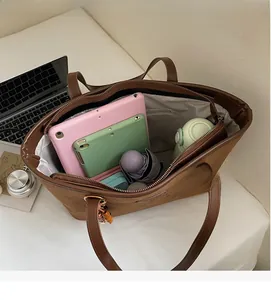 Top view of large brown suede tote bag showing interior space with tablet and essentials