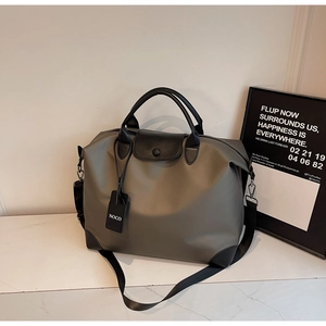 Dettaglio borsa da viaggio in nylon verde oliva con manici neri e finiture rinforzate