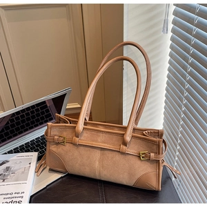 Detailed view of brown suede and leather patchwork shoulder bag with gold buckle
