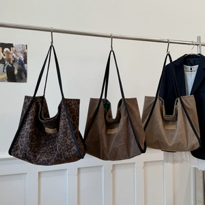 Detailed close-up of large canvas tote bags in leopard print, brown, and tan colors
