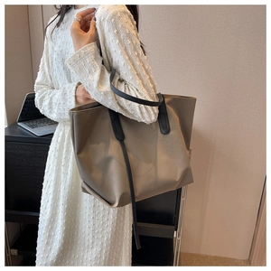 Détail du grand sac cabas oxford kaki avec anses noires dans un décor de bureau