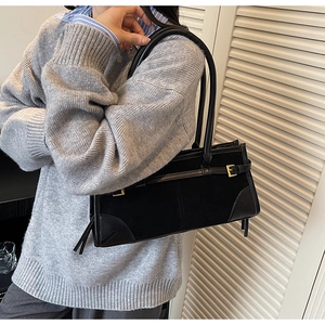 Detail showing high-quality black suede and leather texture with golden buckle hardware