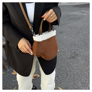 Detail of creative glove-shaped suede handbag with white faux shearling trim and strap