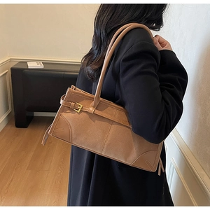 Detailed view of women's khaki shoulder bag showing suede texture and metal buckle detail