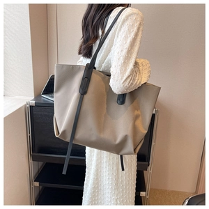 Gros plan d'un sac cabas en tissu Oxford kaki avec anses noires dans un cadre de bureau