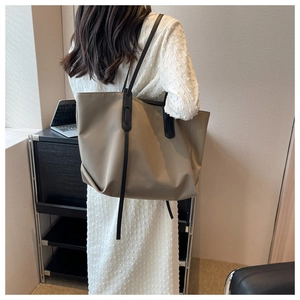 Détail d'un grand sac cabas en tissu oxford kaki avec de fines bandoulières noires pour femme