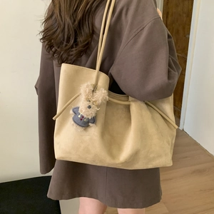 Detail of apricot suede tote bag with large capacity and cute plush puppy charm