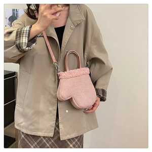 Detailed view of pink faux suede glove-shaped handbag with plush teddy fleece trim detail
