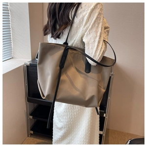 Grand sac fourre-tout Oxford kaki foncé porté à l'épaule dans un intérieur de style minimaliste