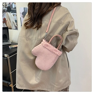 Detailed back view of a pink glove-shaped crossbody bag with fluffy white faux fur trim
