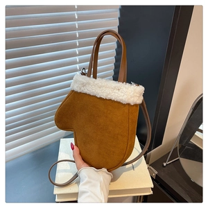 Close-up of caramel suede glove-shaped handbag with white faux shearling fur collar trim