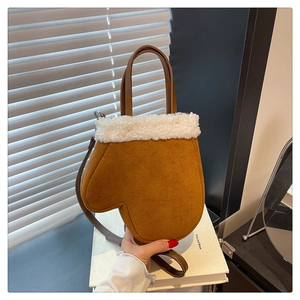 Detail of creative glove-shaped crossbody bag with brown faux suede and white plush trim