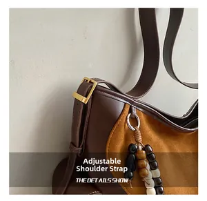 Detail showing the adjustable shoulder strap with gold buckle and beaded bag charm