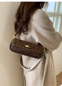 Detailed close-up of retro leopard print baguette bag on a model in wool coat
