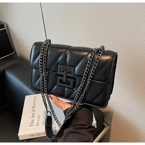 Close-up of black quilted crossbody bag with V-shaped stitching and matte metal H-lock