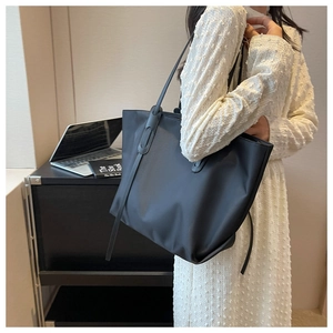 Détail d'un grand sac cabas noir en tissu Oxford avec texture mate et bandoulières