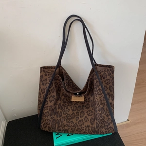 Detail of leopard print tote bag with magnetic clasp and decorative leather patch