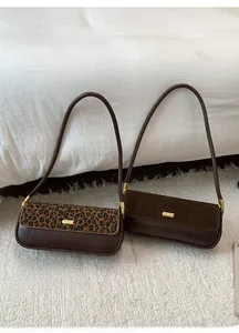 Detailed view of leopard print and brown leather baguette bags with metallic buckles