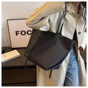 Vue latérale d'un grand sac fourre-tout noir en oxford porté par un mannequin chic