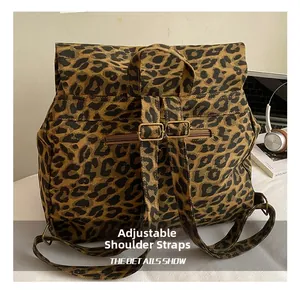 Detail of leopard print backpack featuring adjustable shoulder straps and a back zipper pocket