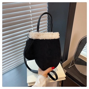 Detail of creative black suede glove-shaped handbag with white faux fur trim and strap