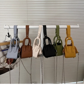 Close-up of mini bucket bags in various colors with ring handles and chain straps