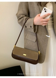Detail shot of a retro minimalist two-tone leather shoulder bag in brown and khaki