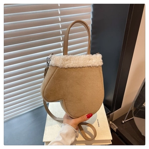 Detail view of khaki suede handbag with white faux fur trim and adjustable strap