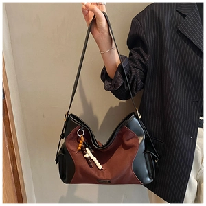 Detail of suede hobo bag with wood bead tassel and smooth leather contrast