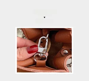 Detail of silver metal hook and brown lychee grain leather on a stylish bucket bag