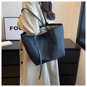 Gros plan du grand sac cabas noir avec doubles anses longues et coutures de renfort