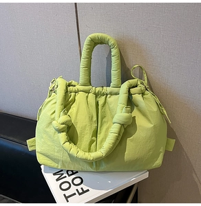 Detail of neon quilted puffer tote bag featuring drawstring closure and padded handle